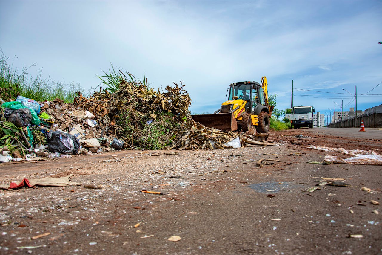Street cleaning operation with bulldozer and debris in Londrina, Brazil.